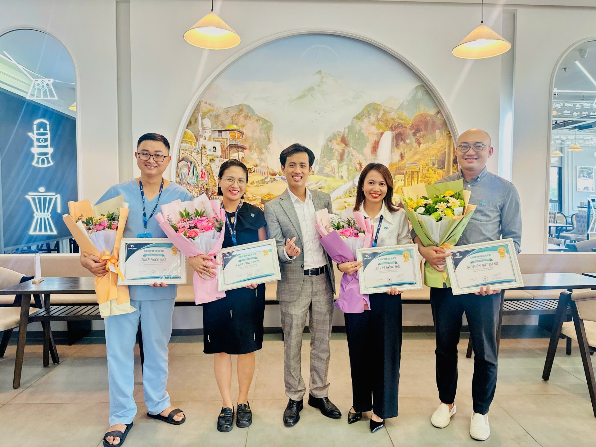 Alex Phuong with trainees holding their course completion certificates